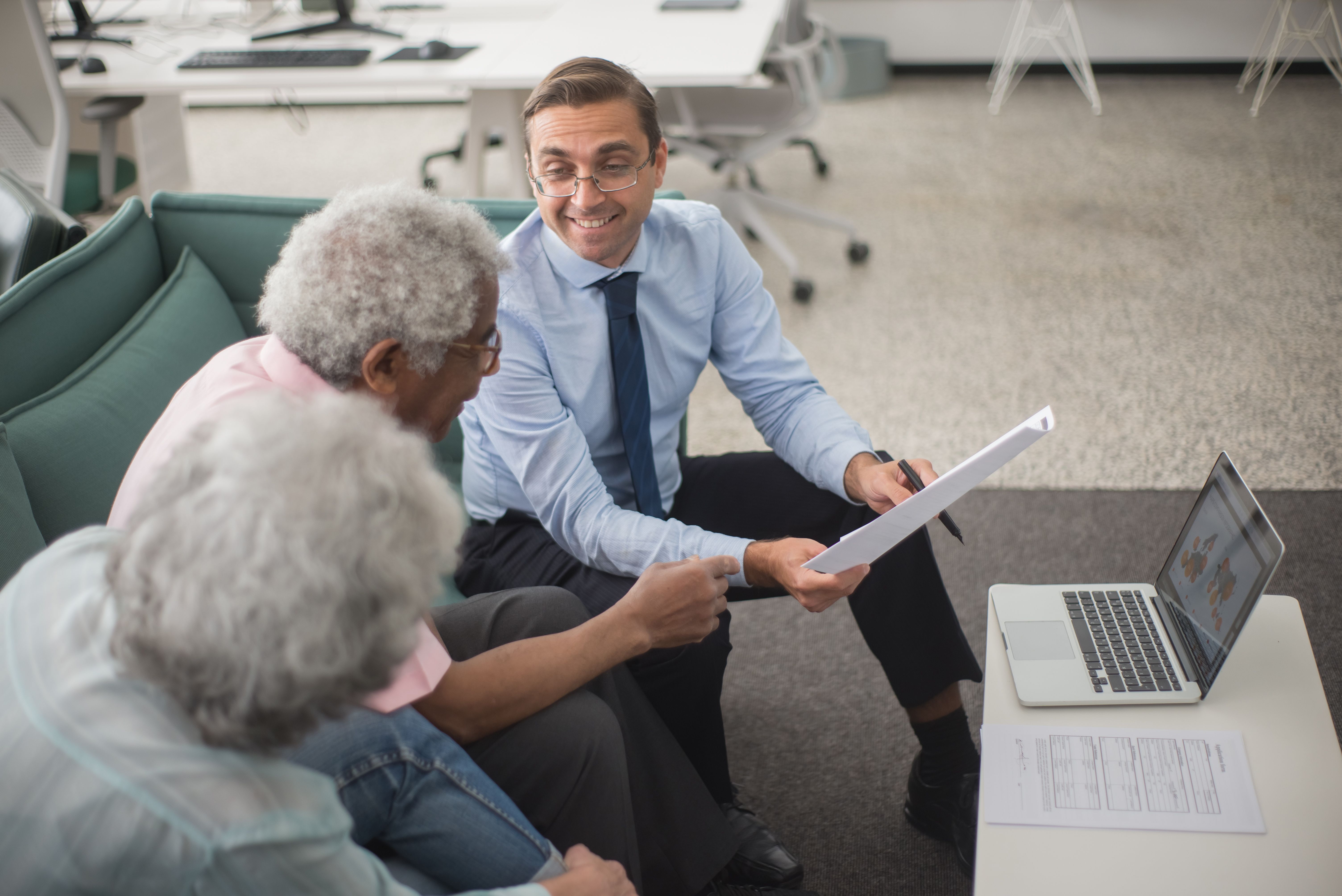 Advisor reviewing paperwork with a couple in an office consultation